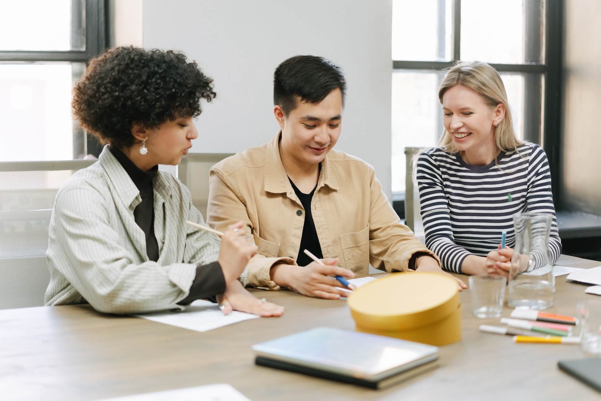 Multiracial couple with their financial advisor going over documents