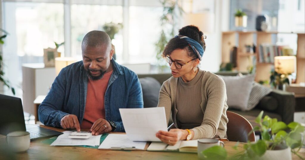 Financial paperwork, counting or African couple with planning or household budget in home. Bills, calculator or people with form documents for accounting report of investment growth, taxes or salary