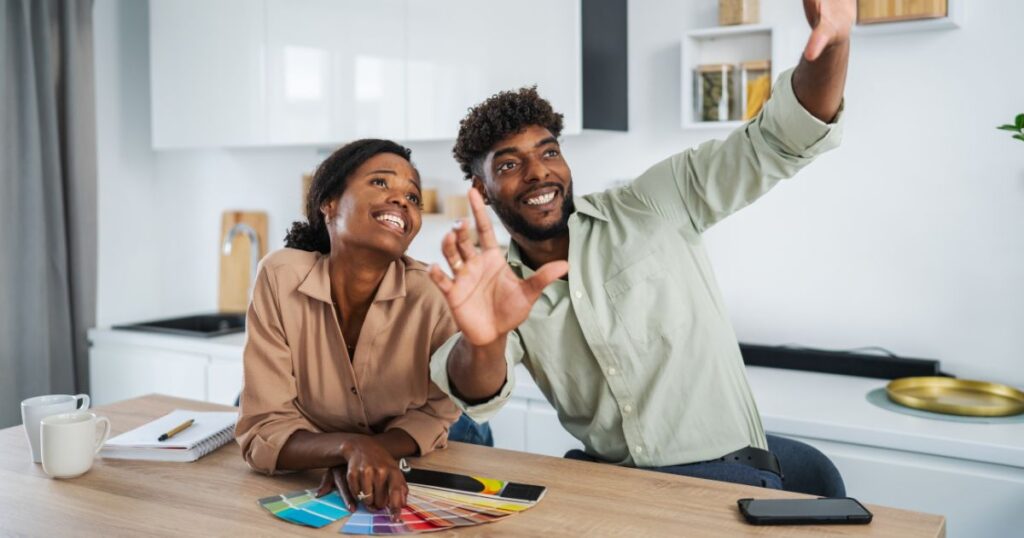 Young black couple planning kitchen renovation selecting colors