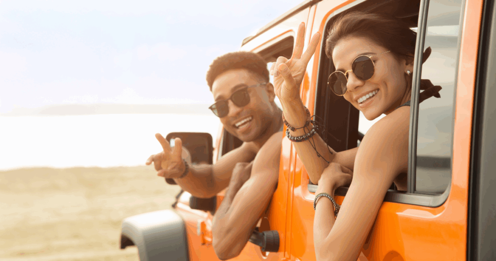 Young teens driving car on beach